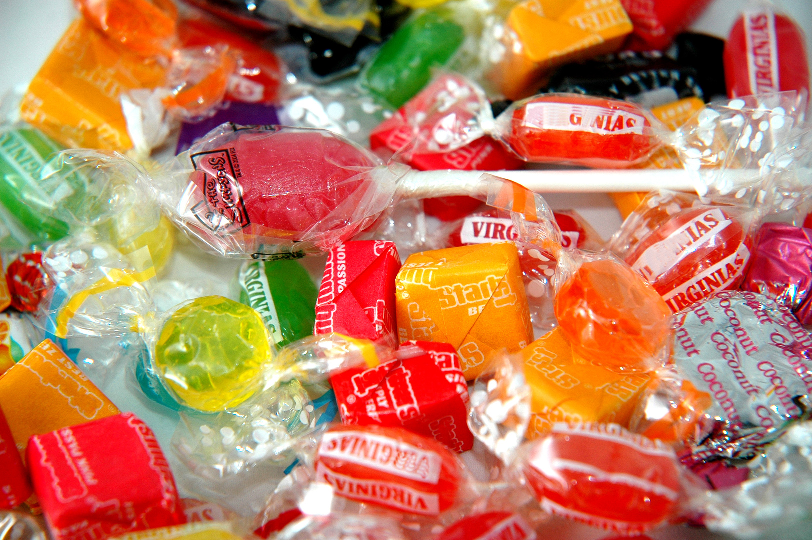 Viele bunte, in transparente Folie verpackte Bonbons und Lutscher.