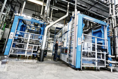 Ruch Novaplast, Fertigungsautomat im Kunststoffwerk, stellt Produkte aus Partikelschäumen her wie Isolations- und Transportboxen