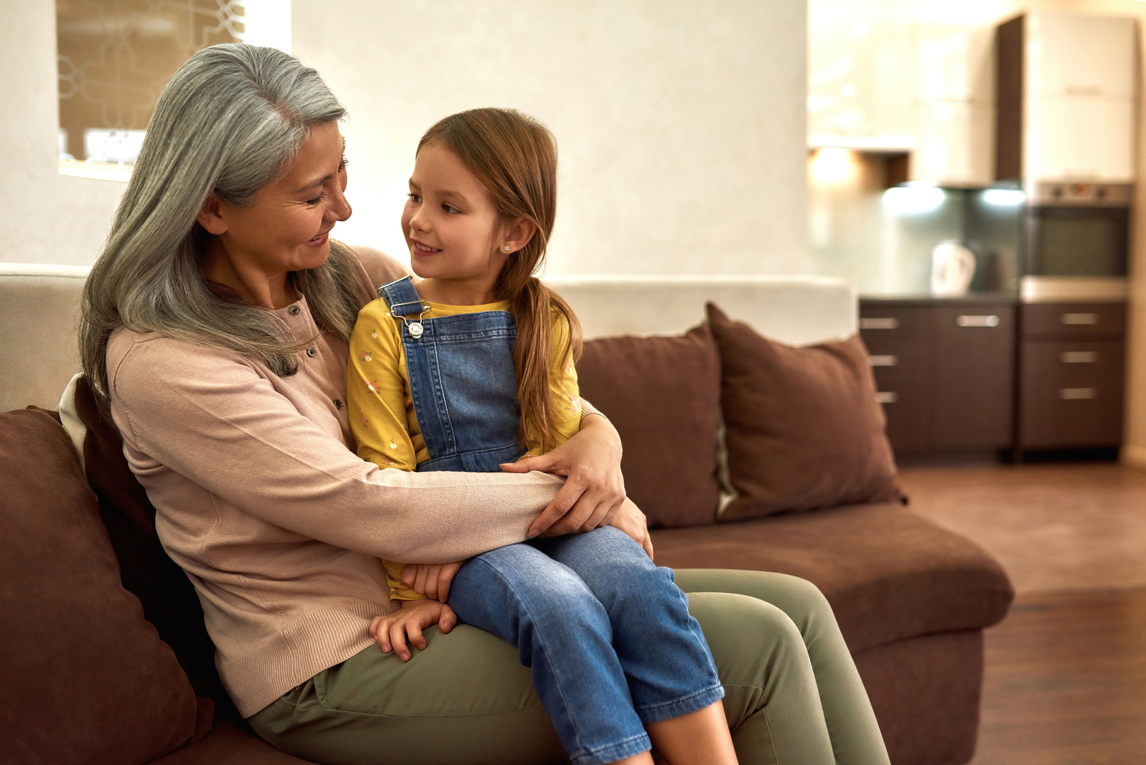 Beautiful mature woman holding preschool girl on her knees